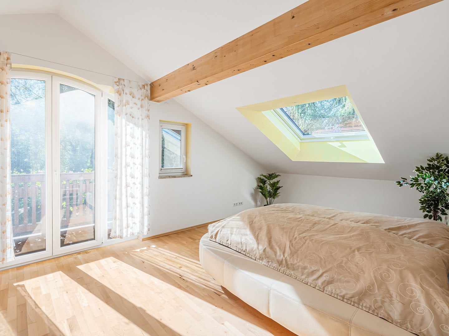 Landhaus Bad Reichenhall – Schlafzimmer mit Sichtpfette, großem Dachflächenfenster und Zugang zum Südost-Balkon